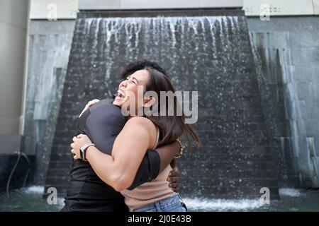 Close up portrait of multiethnic friends embracing in a modern mall Stock Photo