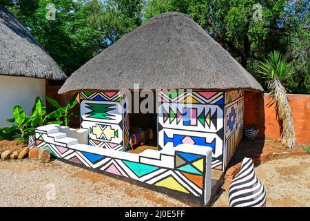 Traditionally-painted Ndebele dwelling at Motseng Cultural Village, Sun City, Pilanesberg, North West Province, South Africa Stock Photo