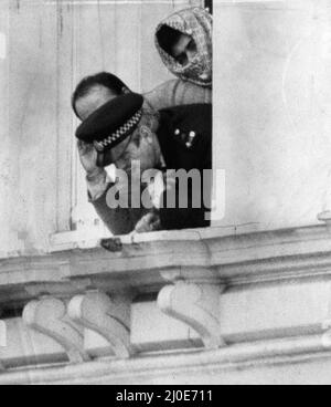 Fifth day of the Iranian Embassy Siege in London where six gunmen of the Iranian extremist group 'Democratic Revolutionary Movement for the Liberation of Arabistan' stormed the building, taking 26 hostages before the SAS retook the embassy and freed the hostages. Hostage policeman Trevor Lock shouts instructions down to police officers below from the Embassy balcony as he stands with another hostage and one of the terrorists looking over his shoulders. 4th May 1980. Stock Photo