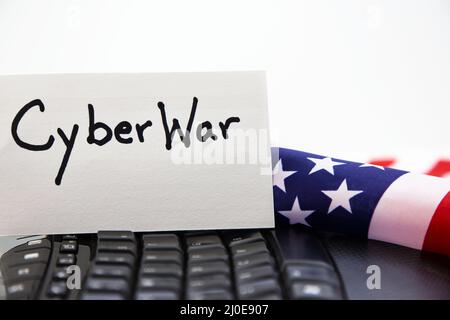 Conceptual image of national threats of cyberattacks against American infrastructure seen in flag, keyboard, and CYBERWAR card still life Stock Photo