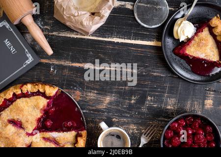 Cherry pie, cup of coffee on dark rustic background Stock Photo