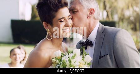 I couldnt be happier for you my angel. Cropped shot of an affectionate mature father kissing his daughter on the cheek on her wedding day. Stock Photo