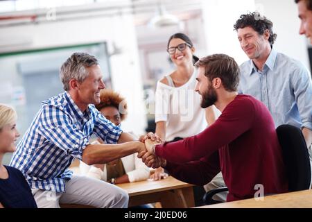 Youve been doing a great job. A mature businessman shaking hands with a colleague during an informal office meeting. Stock Photo