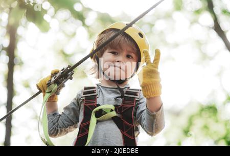 Children summer activities. Kid climbing trees in park. Children fun. Cute baby boy playing. Every childhood matters. Stock Photo