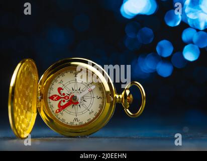 Antique gold clock. Isolated on a dark blue background. Symbol of time, old thing. Beautiful composition. There are no people in the photo. Advertisin Stock Photo
