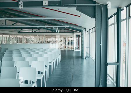 This is where the business starts. Shot of an empty office filled with chairs and surrounded with glass windows on the sides. Stock Photo