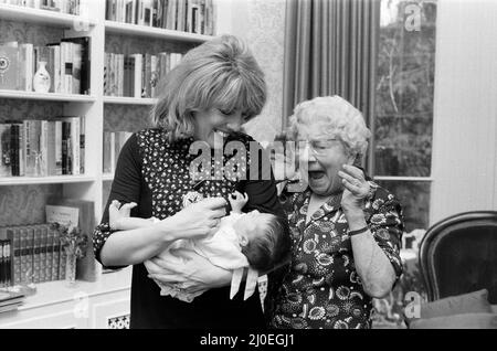 'That's Life' presenter Esther Rantzen presents her month old baby Emily to Annie Mizen today. Annie, 86, who became famous on That's Life by eating caviar and Chinese food, testing drinks and dancing in the street, was invited to elevenses at Esther's home and to meet Emily. 22nd February 1978. Stock Photo