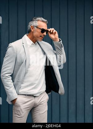 He knows himself and he knows his style. Cropped shot of a smartly dressed mature businessman standing outside. Stock Photo
