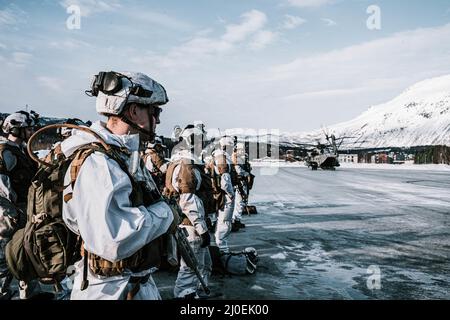 Norwegian soldiers with Armoured Battalion, Brigade Nord, Norwegian Army, wait to load a U.S. Marine Corps CH-53E Super Stallion with Marine Heavy Helicopter Squadron 366 (HMH-366), 2nd Marine Aircraft Wing, during Exercise Cold Response 22 in Setermoen, Norway, March 15, 2022. Exercise Cold Response 22 is a biennial Norwegian national readiness and defense exercise that takes place across Norway, with participation from each of its military services, including 26 North Atlantic Treaty Organization (NATO) allied nations and regional partners. (U.S. Marine Corps photo by Sgt. William Chockey) Stock Photo