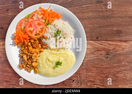 Chicken garnished with rice, mashed potatos and salad Stock Photo