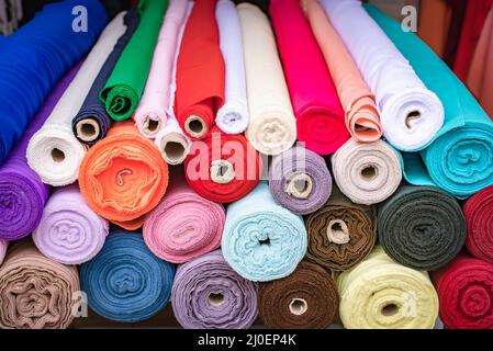 Colorful fabric rolls piled at the store Stock Photo