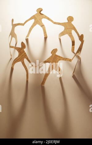Paper dolls holding hands Stock Photo