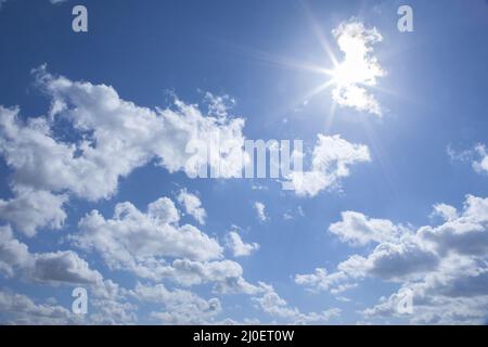 Sun bursting through clouds on a sunny day Stock Photo