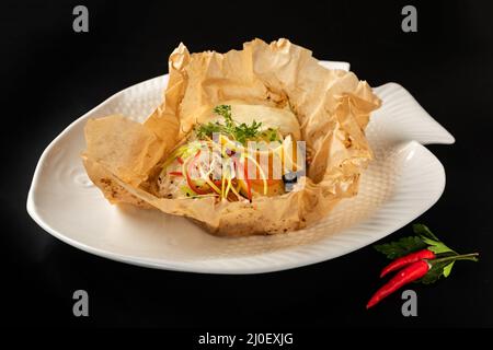 White fish fillet baked in paper parchment Stock Photo