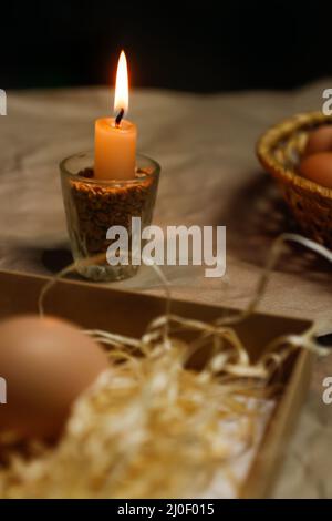 Candle with light. Rustic background. Tools for decorating Paschal eggs, Pysankas. Collection eggs. Homemade pen for drawing eggs. Preparation for Stock Photo