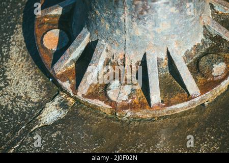 Closeup of a large old rusty pipe bolted to a horizontal surface Stock Photo