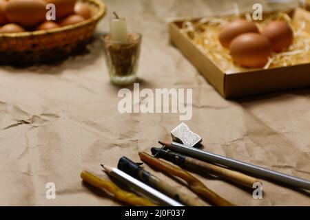 Rustic background. Tools for decorating Paschal eggs, Pysankas. Collection of eggs. Homemade pen and melted beeswax for drawing eggs. Preparation for Stock Photo