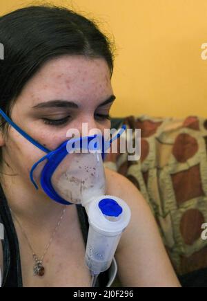 Woman with an inhaler. Doing inhalation at home Stock Photo