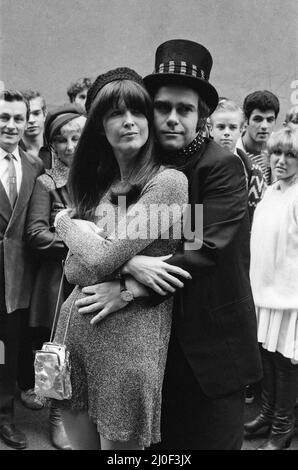 Wearing a top hat, Elton John, at a small studio in Ladbroke Grove to make a promotional film for his new single. Giving the film the feeling of the 1960's in the style of 'Ready Steady Go', Elton invited Cathy McGowan to take part. 5th October 1978. Stock Photo