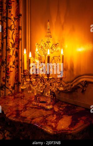 Candle chandelier on a granite table top in an old-fashioned interior Stock Photo