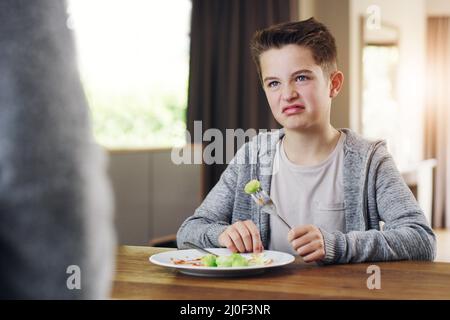 Id rather go to bed hungry. Shot of a young boy refusing to eat his brussels sprouts at home. Stock Photo