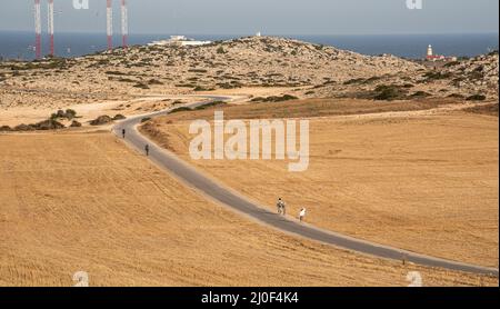 People walking on a road at Cape Greko peninsula in Cyprus Stock Photo