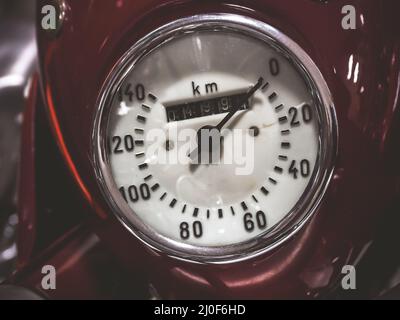 Closeup photo of a round speedometer of an old red motorcycle Stock Photo