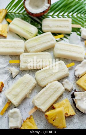 Summer popsicles on stick. Pinacolada flavour. Made with pineapple, cocount milk, rum. Vegan snack Stock Photo