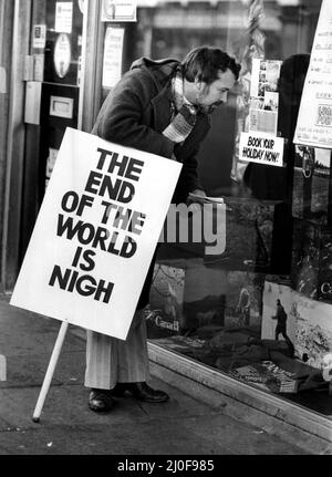 A picture from a series of humurous novelty images taken by Sunday People photographer Dennis Hutchinson. - The end of the world is nigh buit not before you get your holidays booked !   Circa: 1980 Stock Photo