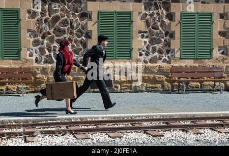 Young couple with vintage suitcase on the trainlines ready for a journey. Stock Photo