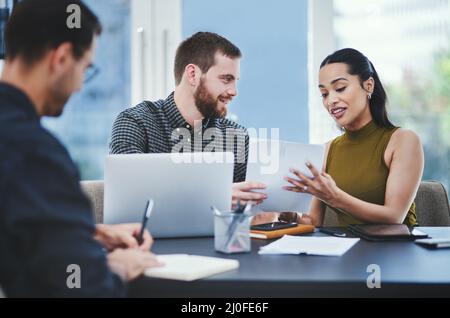 Executing their plans to the detail. Shot of a group of young designers having a discussion in an office. Stock Photo
