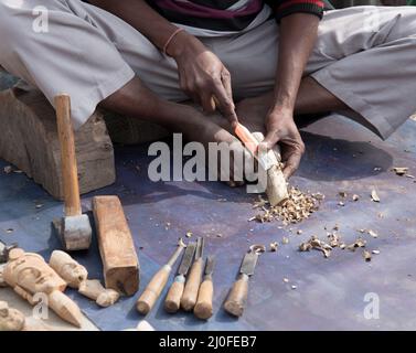 Artist carving wood to make wooden sculptures. People working Stock Photo