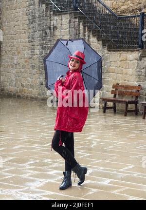 Young woman standing in the rain Stock Photo