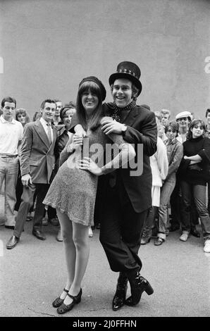 Wearing a top hat, Elton John, at a small studio in Ladbroke Grove to make a promotional film for his new single. Giving the film the feeling of the 1960's in the style of 'Ready Steady Go', Elton invited Cathy McGowan to take part. 5th October 1978. Stock Photo