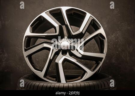 new stylish cool alloy wheel on the tire dark textured background,  beautiful and expensive 20 -21, 22 ,large diameter copyspace on the left,  fragment Stock Photo - Alamy