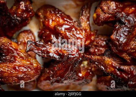 Close up on Chicken wings in thick barbecue sauce. Served on white cast iron dish Stock Photo
