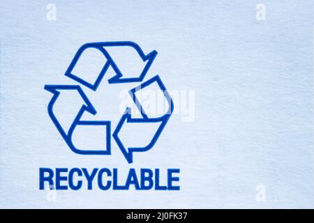 Recyclable symbol on a white cardboard. Stock Photo