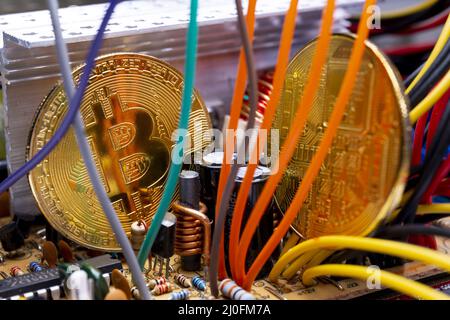 Bitcoin coins, colorful cables and printed circuit board PCB Stock Photo