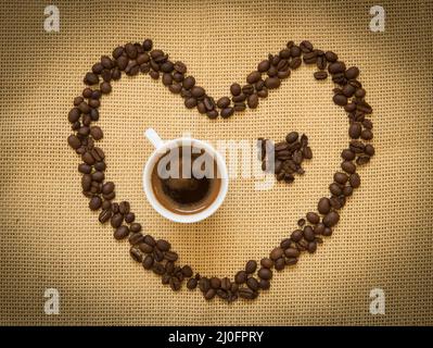 Fresh black coffee and beans creating a heart shape. Coffee lovers Stock Photo