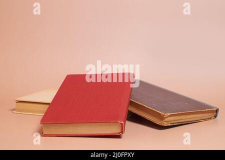 A stack of old worn books on a colored background Stock Photo