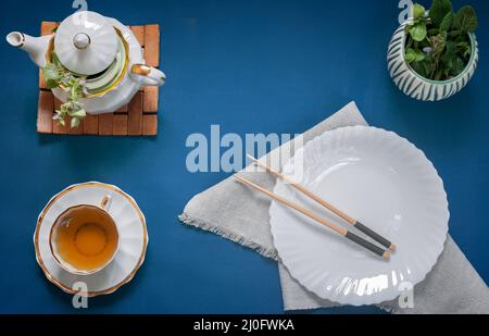 Empty white plate, chopsticks and herbal tea Stock Photo