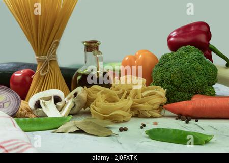 Dry and cheesy pasta with vegetables on the table. Mixed selection of dried pasta on a wooden background. copy space Stock Photo