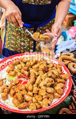 Sai ua or northern Thai sausage, contains minced pork meat, herbs, spices, and kaeng khua red curry paste. It is usually eaten g Stock Photo
