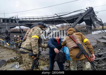 IRPIN, UKRAINE 03 March .Ukrainian troops help civilians cross the shelled bridge connecting the town of Irpin and Kiev, as the war with Russian continue on 03 March 2022 in Irpin, Ukraine. Russia began a military invasion of Ukraine on 24 February 2022 after Russia's parliament approved treaties with two breakaway regions in eastern Ukraine. It is the largest military conflict in Europe since World War II. Stock Photo