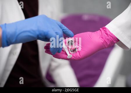 The doctor gives the trainee a vial with a medicine and a syringe as a set for injections, including flu and COVID19 vaccines. A Stock Photo