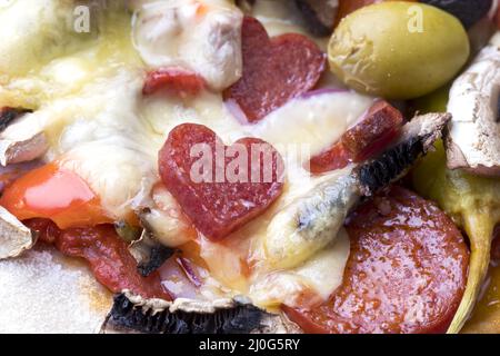 Heart shaped salami on a pizza Stock Photo
