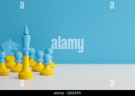 Blue and yellow Ukrainian chess set on blue background Stock Photo
