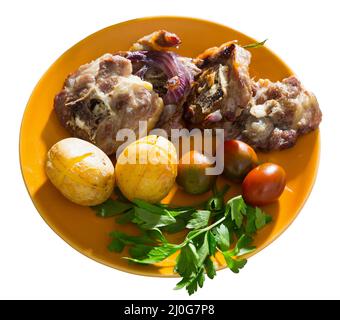 Lamb leg chops with baked potatoes, tomatoes and greens Stock Photo