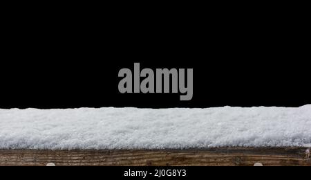 Empty wooden table snow covered with snowfall isolated on black background Stock Photo