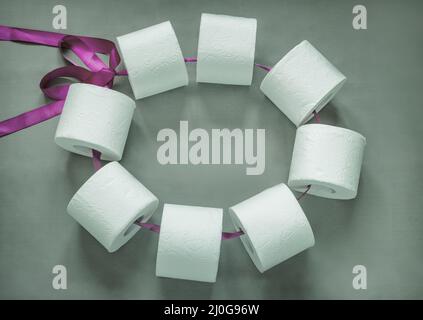 Toilet paper rolls connected by a ribbon in a bundle. Stock Photo